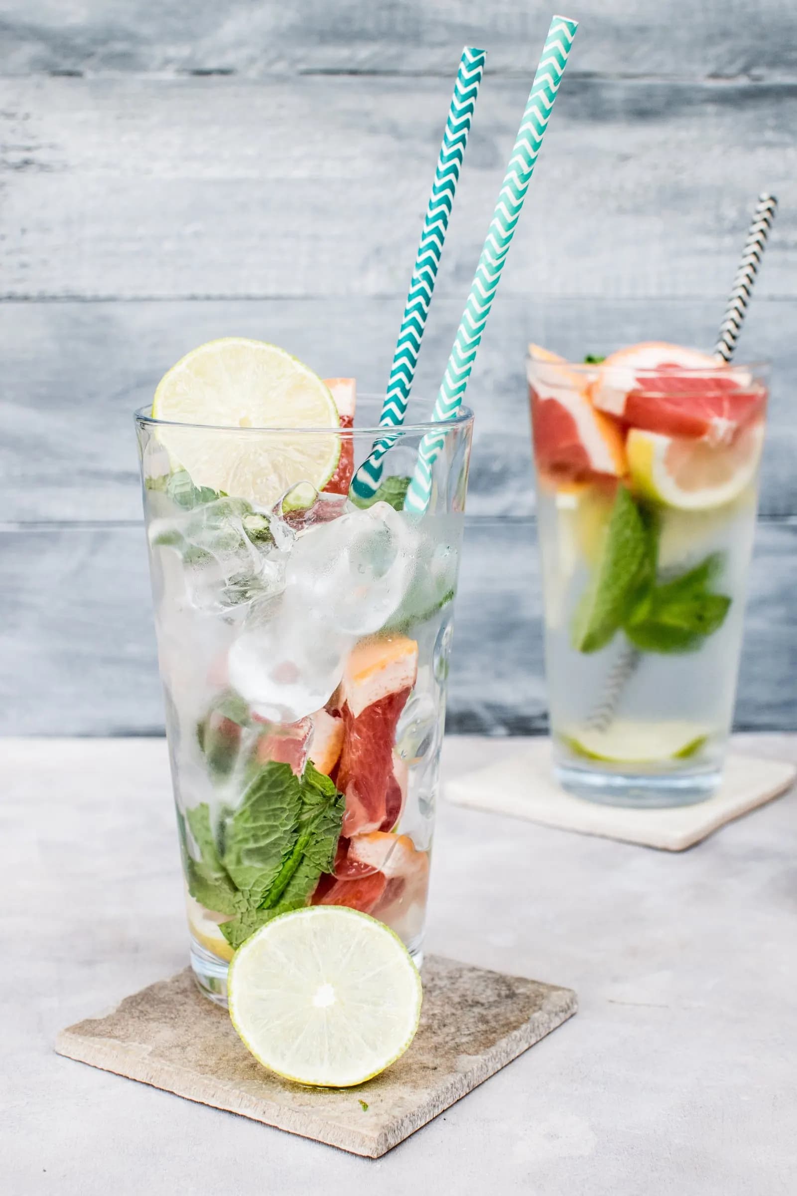 Gläser mit Detox Water, Zitrusscheiben und Minze